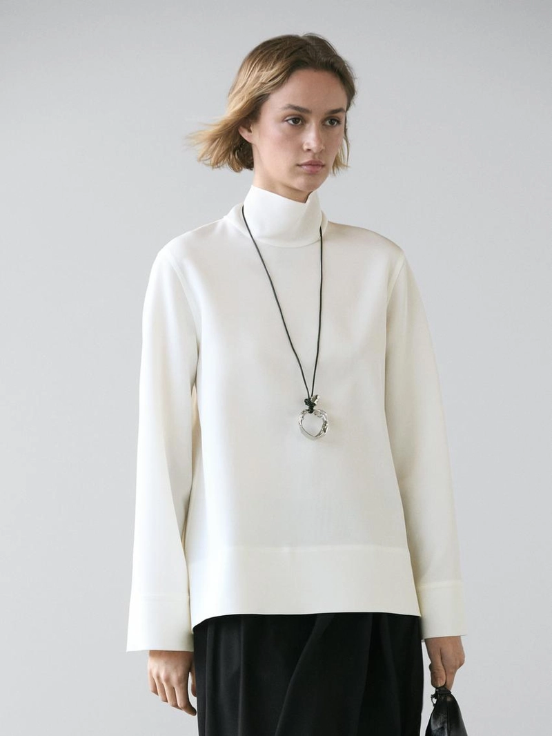 Блузка с высоким воротником и деталями на подоле