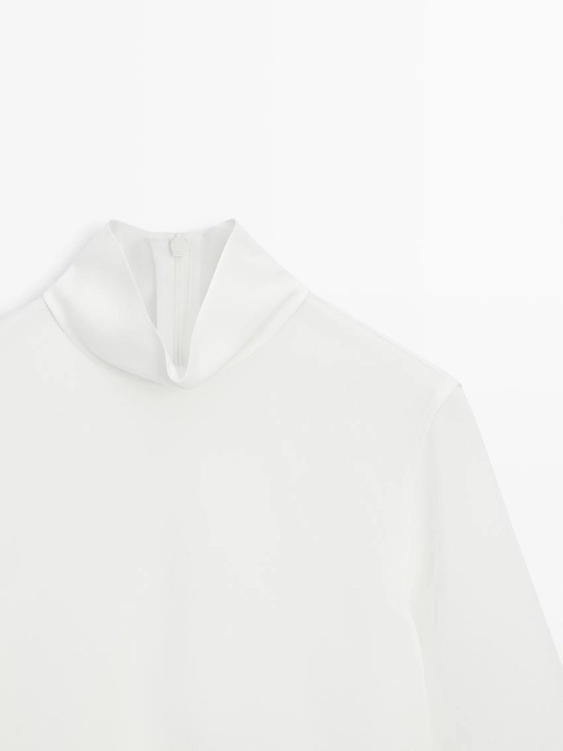 Блузка с высоким воротником и деталями на подоле