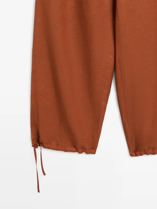 Брюки со свободным кроем и деталью на завязке- Заказать в России