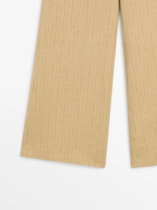 Брюки из льна с расширяющимся кроем и полосатыми деталями- Заказать в России